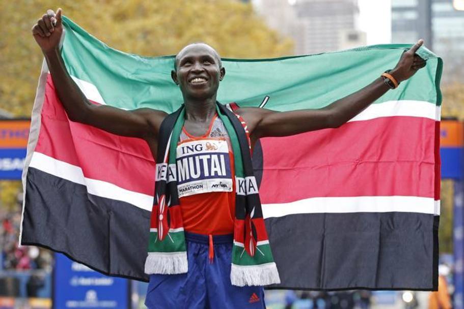 Il vincitore Geoffrey Mutai festeggia con la bandiera del Kenia.